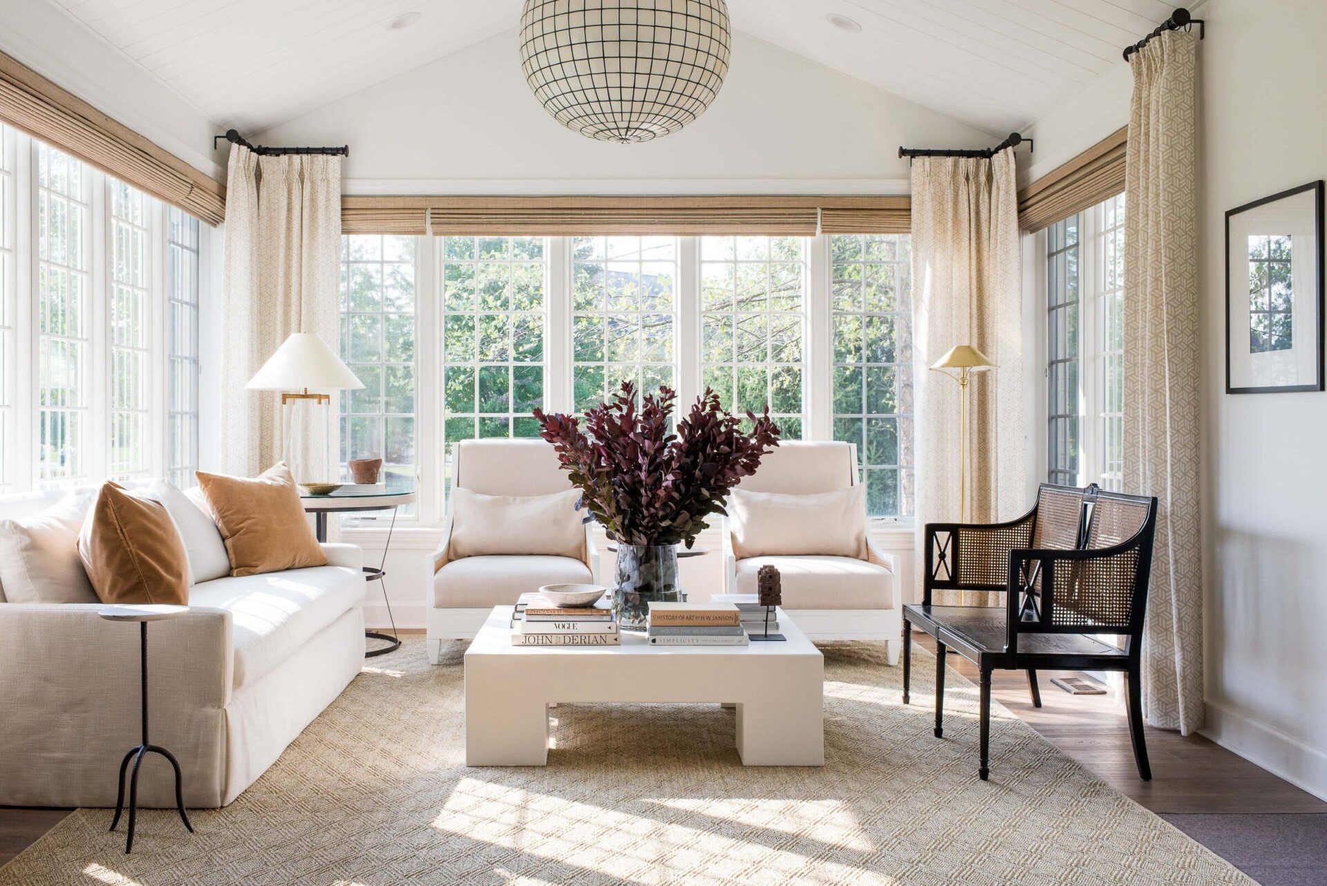 sunlit living room with large windows and comfortable seating area