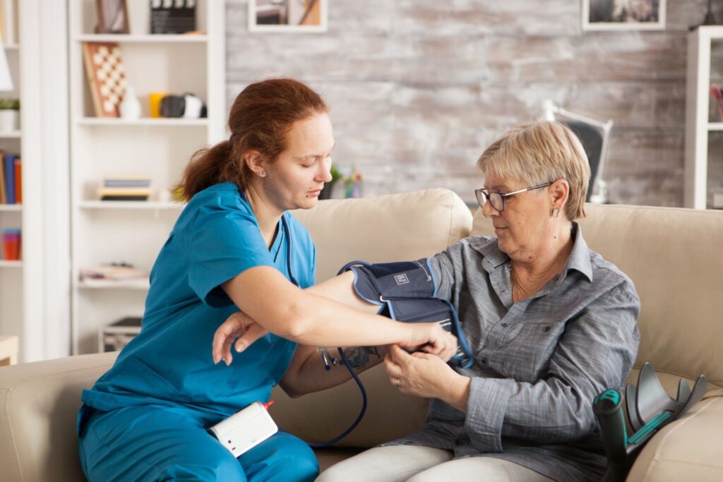 A care worker checking the blood pressure of a client.